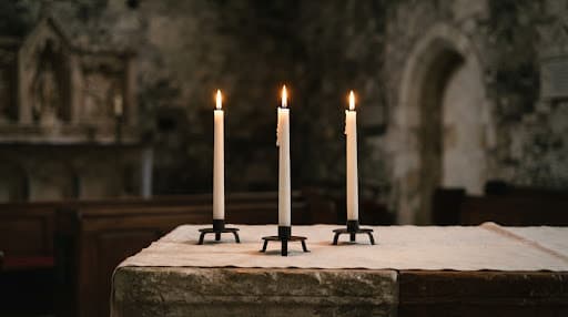White beeswax candles glowing on a stone altar